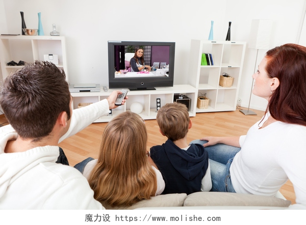 年轻的家庭一起在客厅看电视年轻的家庭，在家里看电视